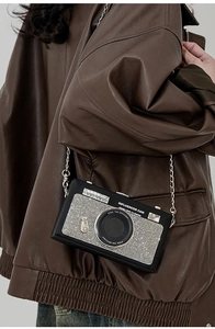 Dettaglio della borsa a tracolla a forma di macchina fotografica con strass e catena