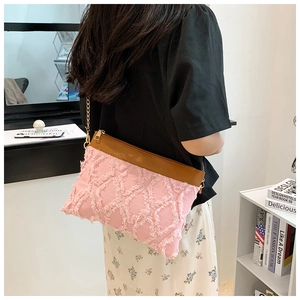 Sac bandoulière rose matelassé avec texture frangée, garniture cuir et chaîne dorée