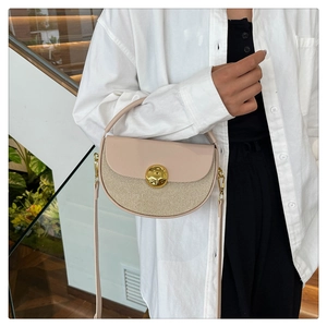Detail of beige leather and straw woven handbag with gold metal clasp on model