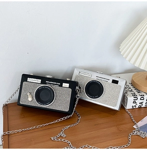 Macro di eleganti borse a forma di fotocamera con strass luccicanti e tracolla a catena