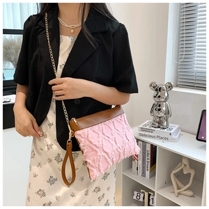 Sac bandoulière matelassé rose avec finitions en cuir marron et détails de chaîne dorée