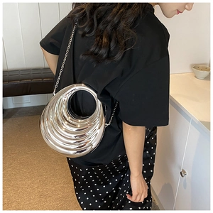 Silver metallic crossbody bag with circular hollow design and ripple texture detail