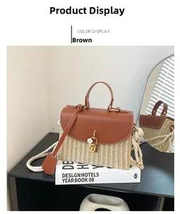 Dettaglio della borsa in paglia intrecciata con finiture in pelle marrone e fibbia dorata