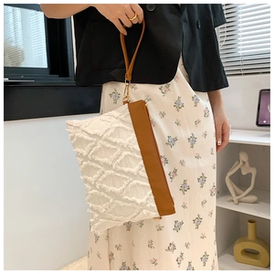 Détail du sac à franges beige avec bandoulière en cuir marron et finitions dorées chic