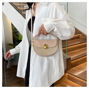 Detail of half-moon saddle bag with contrast textures and golden circular lock