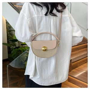 Beige semicircular woven crossbody bag styled with a modern outfit in a bright interior