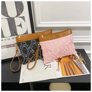 Détail de sacs bandoulière en denim rose et noir avec matelassage et chaînes dorées
