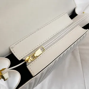 Detailansicht des glatten goldenen Metallreißverschlusses an der weißen Handtasche