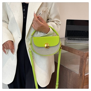 Neon green half-moon crossbody bag with striped canvas and gold lock shown on model