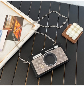 Dettaglio della borsa retrò a forma di fotocamera con lente in strass scintillanti