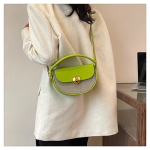 Detail of lime green half-moon crossbody bag with gold round lock and textured fabric