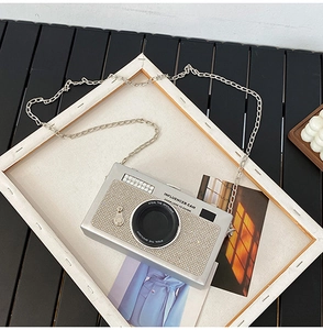 Dettaglio macro della borsa a fotocamera argentata con strass e tracolla a catena
