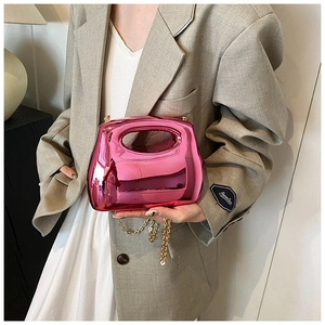Detail of rose pink metallic acrylic bag with hollow handle and gold chain strap