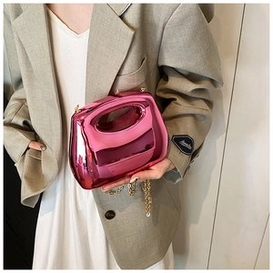 Fashionable magenta acrylic handbag with metallic finish worn with a grey blazer