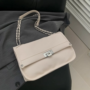 Chic beige lychee leather messenger bag with silver chain strap on a sofa background