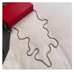 Detail of red matte rectangular bag featuring a silver snake chain and lobster clasp