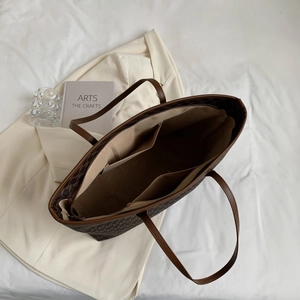 Detailansicht der großen braunen Monogramm-Tote-Bag mit Fächern und praktischen Henkeln.