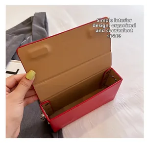 Macro view showing the internal minimalist space and camel suede lining of the red bag