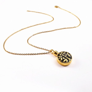 Close-up of golden Tree of Life pendant with black enamel finish on stainless steel chain