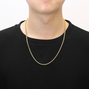Collier chaîne tressée dorée minimaliste pour hommes et femmes sur un t-shirt noir