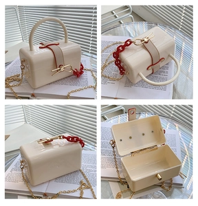 Creamy white acrylic box bag with metal chain strap and top handle view
