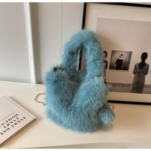 Light blue fluffy plush handbag with stylish chain strap and cute pom-pom charm for women.