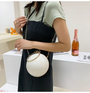Detail of white pearl sphere evening bag with rhinestone circular handle and chain