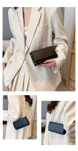 Detail of minimalist black PU leather flap bag with embossed logo and metal chain strap