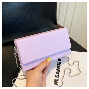 Close-up of lavender rectangular chain bag with silver chain and embossed logo detail