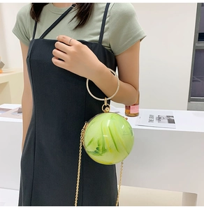 Detail of light green marble effect round clutch with gold rhinestone ring handle and chain