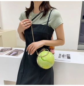 Spherical evening clutch bag featuring yellow-green marble texture and gold metal handle