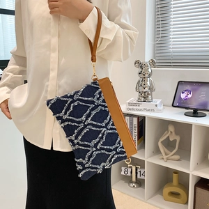 Pochette enveloppe en denim bleu marine avec texture matelassée et lanière en cuir