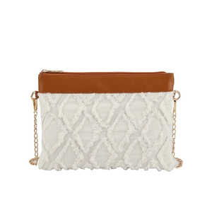 Sac bandoulière blanc à texture matelassée, garniture en cuir brun et chaîne dorée