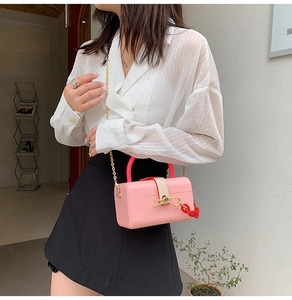 Detailed view of a pink box-style jelly bag with gold chain strap and red accents