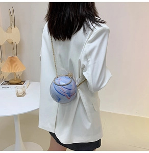 Detail of a spherical crossbody bag featuring artistic red blue marble patterns