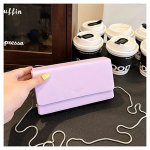 Detail of lavender purple small square bag with silver chain and brand embossing