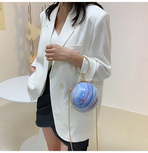 Detail of spherical marble pattern evening bag with round gold handle and chain strap