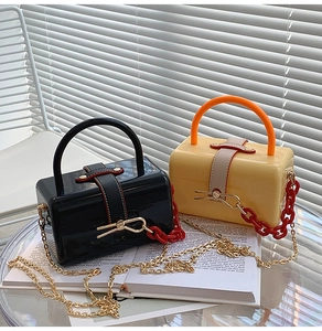 Elegant mini box bags with acrylic chains and metal straps in a French lifestyle setting