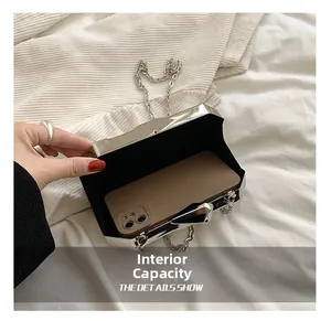 Detail of silver acrylic clutch bag showing interior capacity and sleek metallic finish