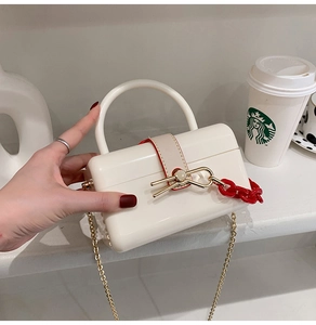 Creamy white acrylic vanity box bag with red chain and golden twist lock detail