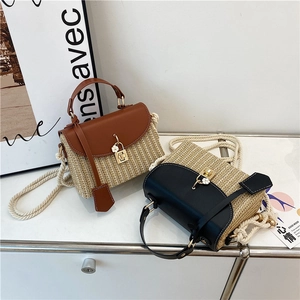 Borsa a mano in paglia intrecciata con patta in pelle e ciondolo a fiore in due colori