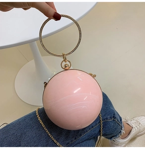 Pink marble spherical evening bag with rhinestone-studded gold ring handle and chain