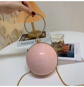 Close-up of pink marble texture round evening bag with diamond-encrusted ring handle