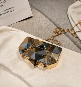 Macro shot of geometric faceted metallic clutch with gold and silver tone reflections