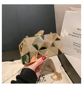 Detailed view of a gold geometric faceted evening clutch bag with metallic mirror finish