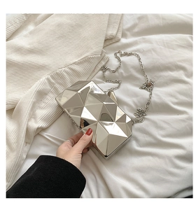 Close-up of silver geometric 3D cube clutch bag with elegant metal chain strap