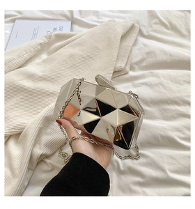 Detail of silver geometric mirror clutch bag with metallic chain strap and top clasp