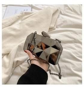 Detail shot of a geometric water cube evening bag with metallic silver finish and chain strap