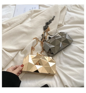 Detail of geometric acrylic evening bags in gold and grey with elegant metal chains