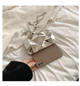 Silver geometric evening bag shown with phone to demonstrate interior storage capacity